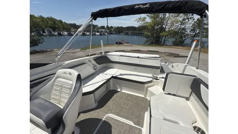 Slide: The Image of 2016 Sea Ray SPX 210 boat interior with seating, docked by a scenic lake. - 6