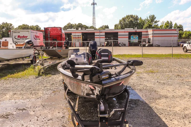 Slide: The Image of 2020 Ranger VS1660 SC boat on trailer in outdoor lot, with trucks and building in background. - 7