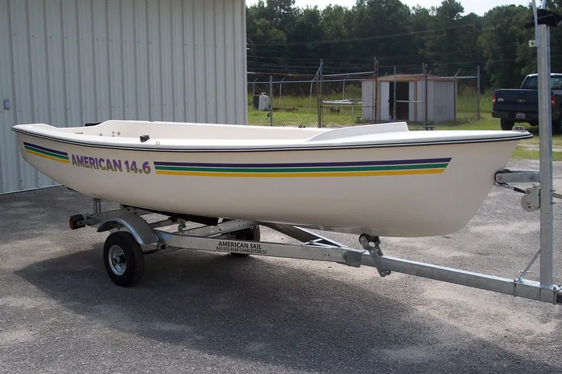 Slide: The Image of American Sail AMERICAN 14.6 sailboat on trailer, 2025 model, parked outdoors. - 8