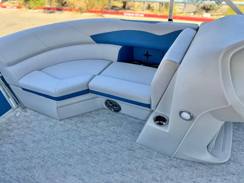 Slide: The Image of 2025 Berkshire 22RFX LE boat interior with gray and blue seating, cup holders, and carpeted flooring. - 10