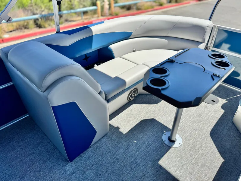 Slide: The Image of 2025 Berkshire 22RFX LE boat interior with blue and gray seating and a table with cup holders. - 14