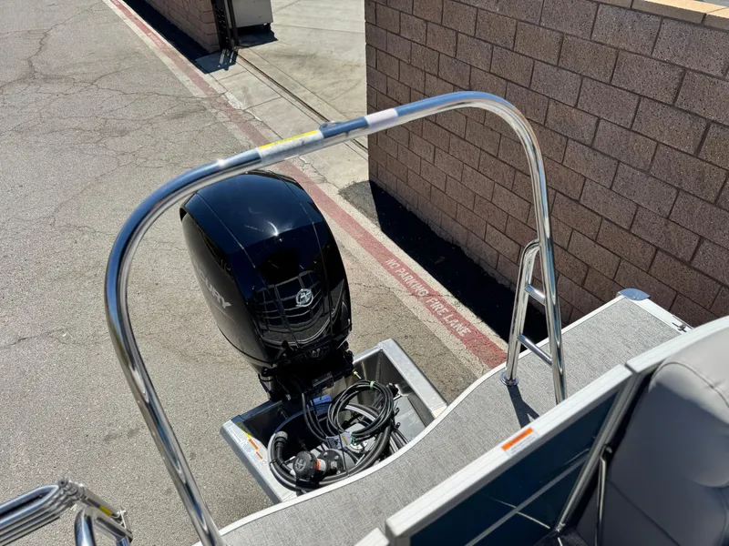 Slide: The Image of 2025 Berkshire 22RFX LE boat with outboard motor, parked on pavement near brick wall. - 16