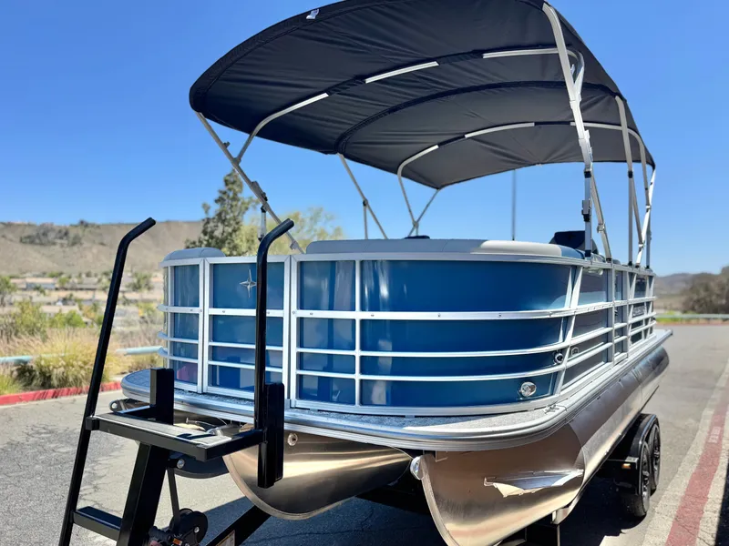 Slide: The Image of 2025 Berkshire 22RFX LE pontoon boat with canopy, parked on a sunny day. - 3