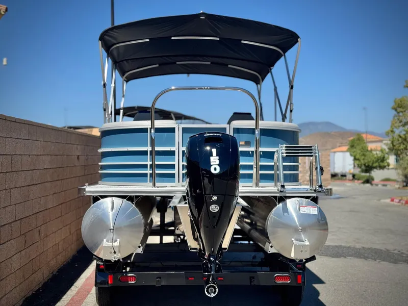 Slide: The Image of 2025 Berkshire 22RFX LE pontoon boat with 150 HP engine, parked outdoors. - 4