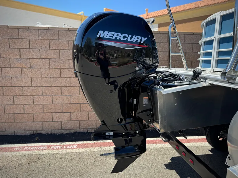 Slide: The Image of 2025 Berkshire 22RFX LE boat with Mercury outboard motor, parked near brick wall. - 6