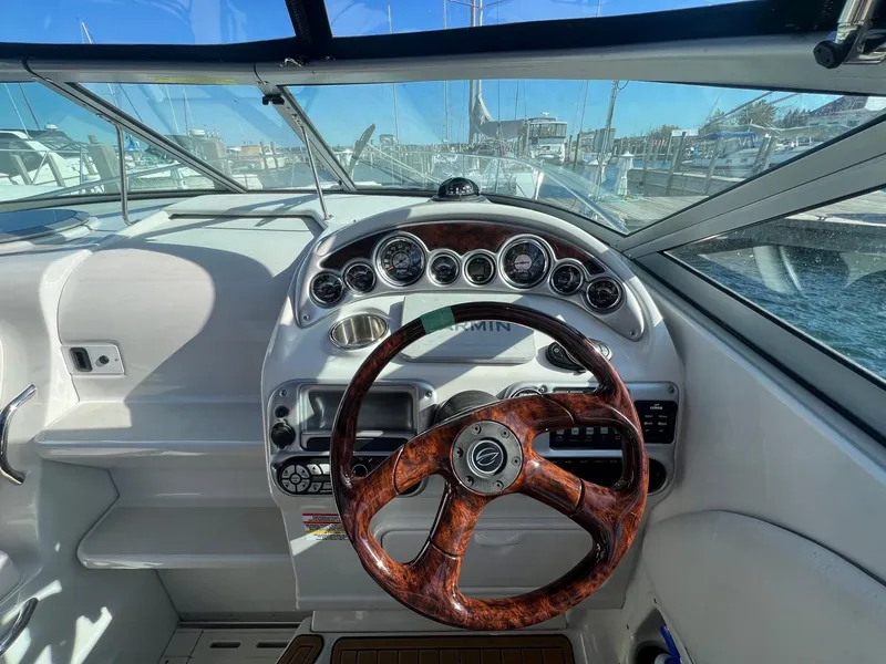 Slide: The Image of 2008 Crownline 270 CR boat dashboard with wood-grain steering wheel and instrument panel. - 12