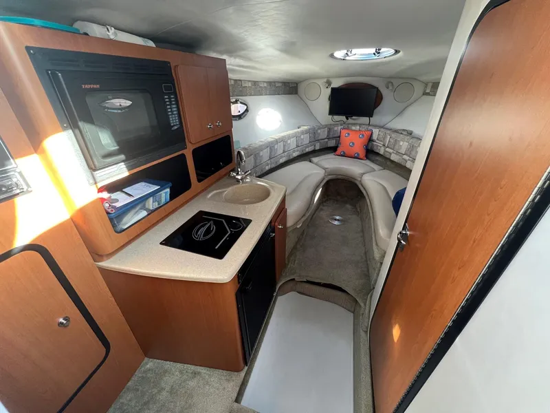 Slide: The Image of Interior of 2008 Crownline 270 CR boat with kitchenette and seating area. - 17