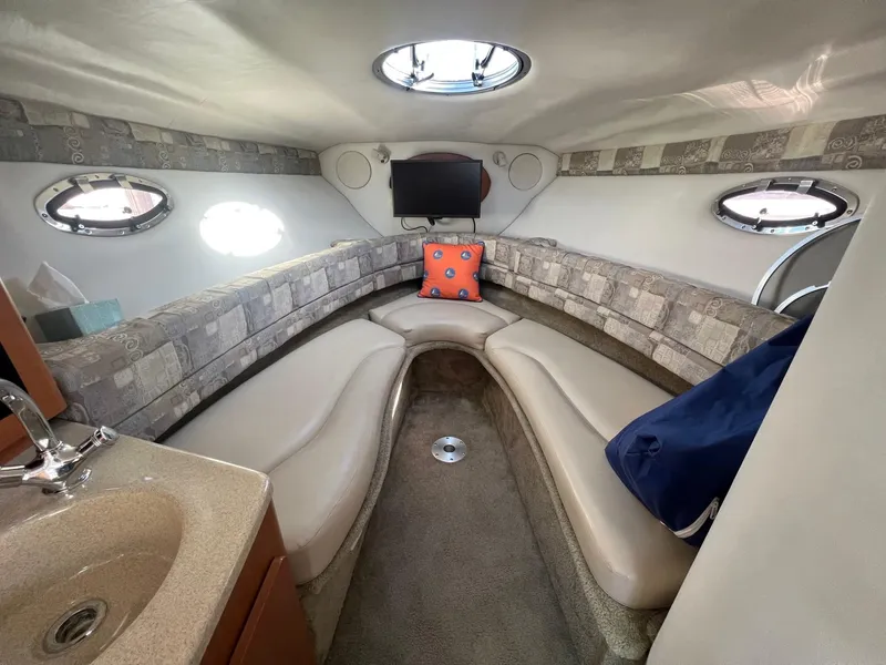Slide: The Image of 2008 Crownline 270 CR cabin interior with seating, sink, and portholes. - 18