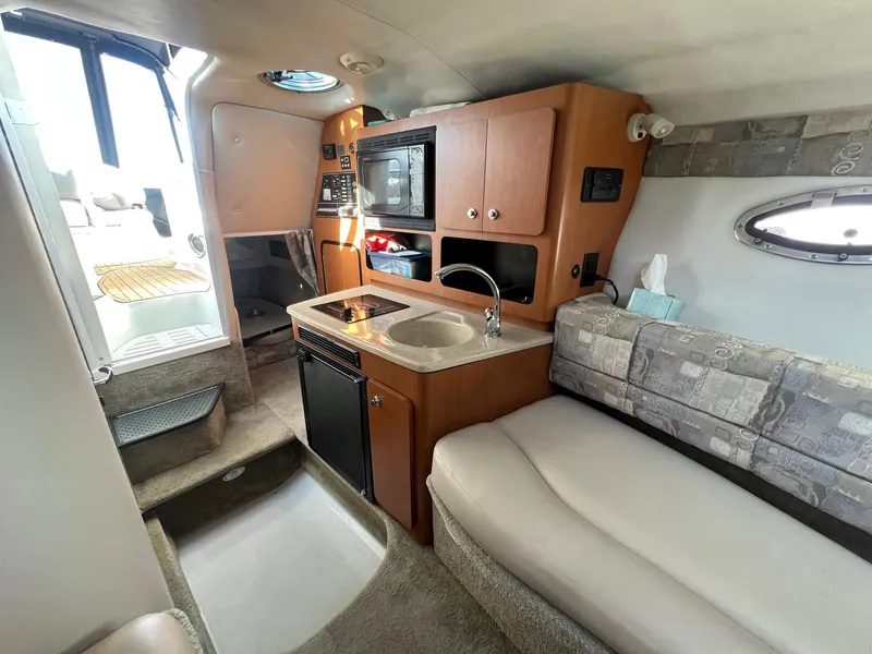 Slide: The Image of Interior of 2008 Crownline 270 CR boat with kitchenette and seating area. - 19