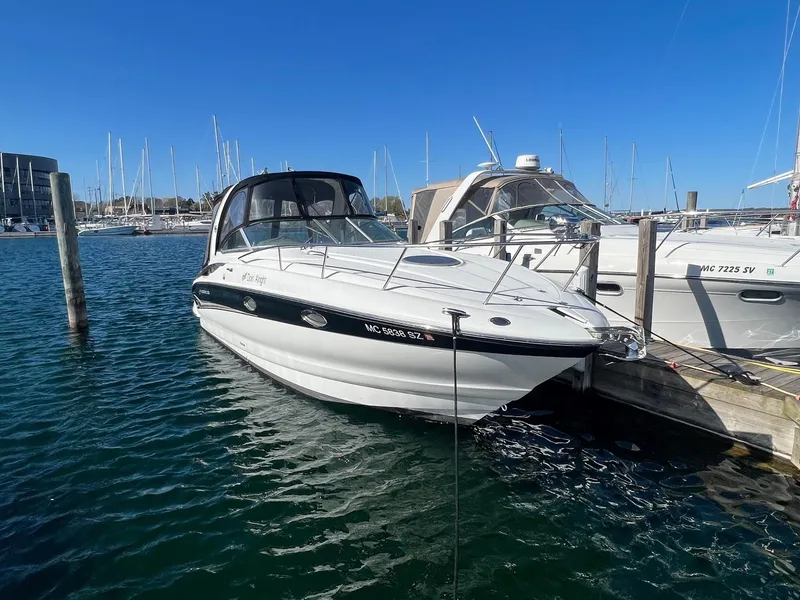 Slide: The Image of 2008 Crownline 270 CR boat docked in a marina under clear blue skies. - 2