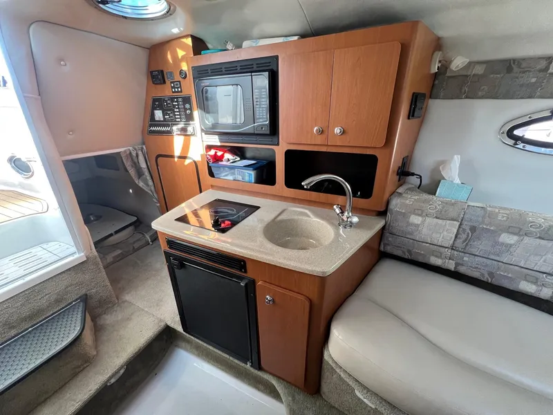 Slide: The Image of 2008 Crownline 270 CR cabin interior with kitchenette, sink, and seating area. - 20