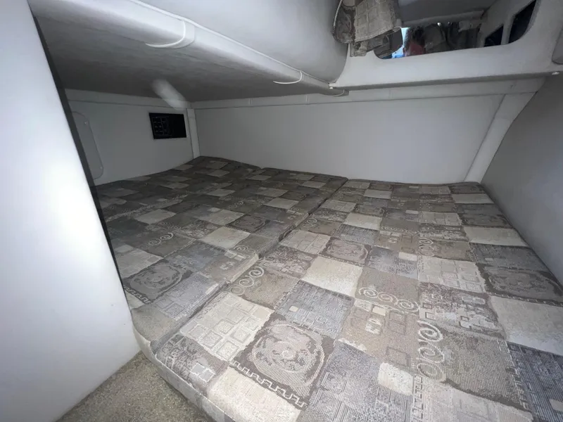 Slide: The Image of 2008 Crownline 270 CR cabin interior with patterned bedding and compact design. - 22