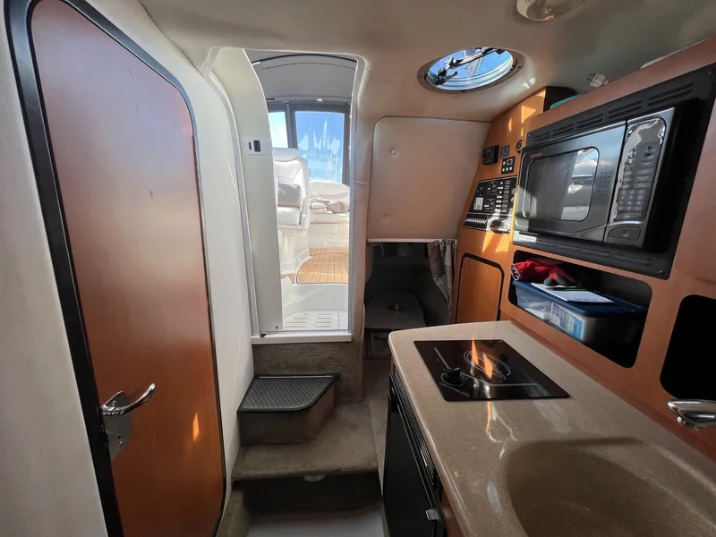Slide: The Image of Interior of 2008 Crownline 270 CR boat with kitchenette and seating area. - 24