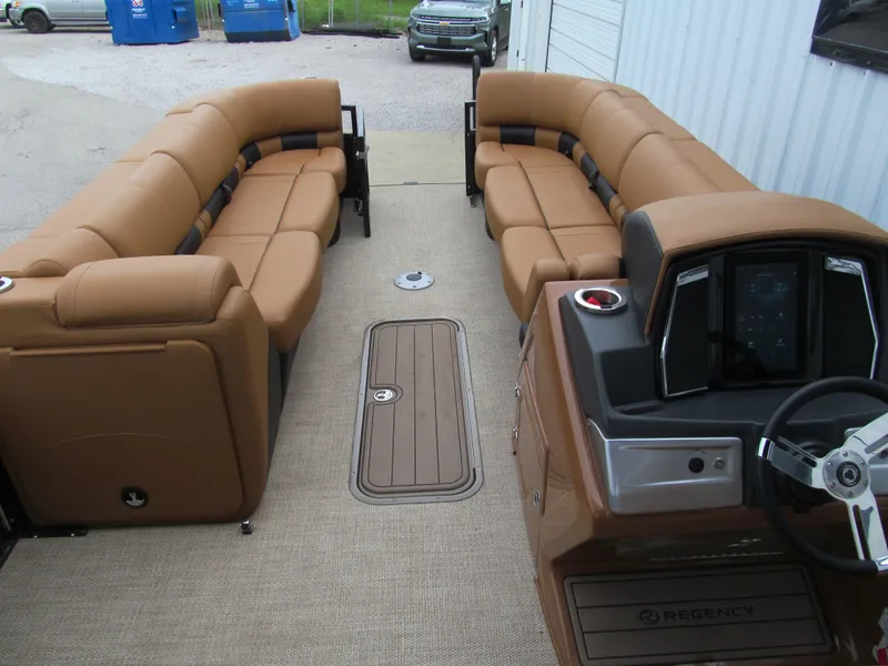 Slide: The Image of 2022 Regency 250 LE3 Sport pontoon boat interior with tan seating and modern helm. - 10