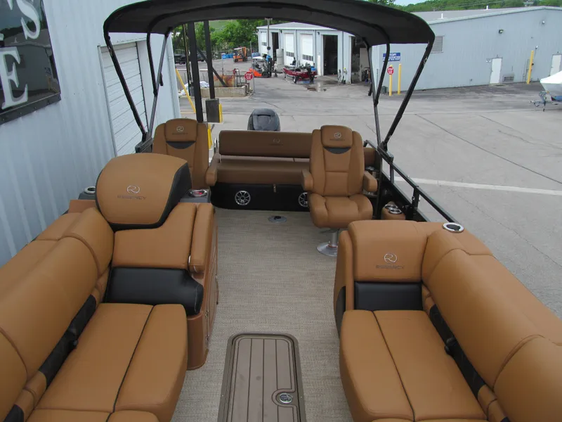 Slide: The Image of 2022 Regency 250 LE3 Sport boat with tan seating and canopy in a marina setting. - 14