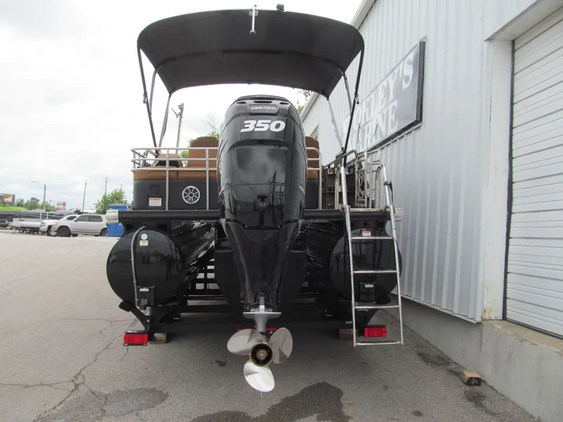 Slide: The Image of 2022 Regency 250 LE3 Sport boat with 350 horsepower engine, docked near a warehouse. - 4