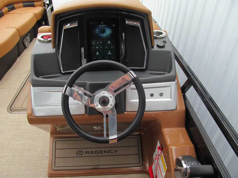 Slide: The Image of 2022 Regency 250 LE3 Sport boat dashboard with steering wheel and control panel. - 9