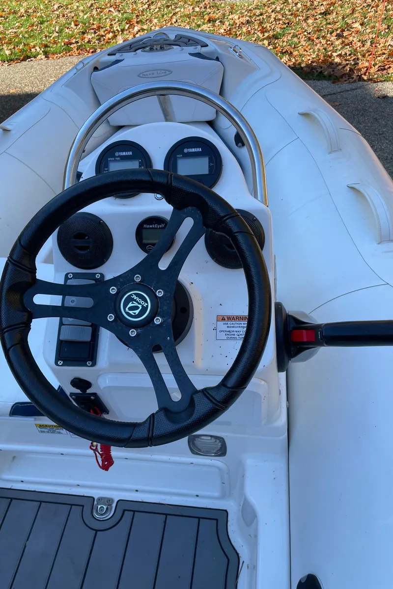 Slide: The Image of 2022 Zodiac Yachtline 360 boat dashboard with steering wheel and controls. - 14