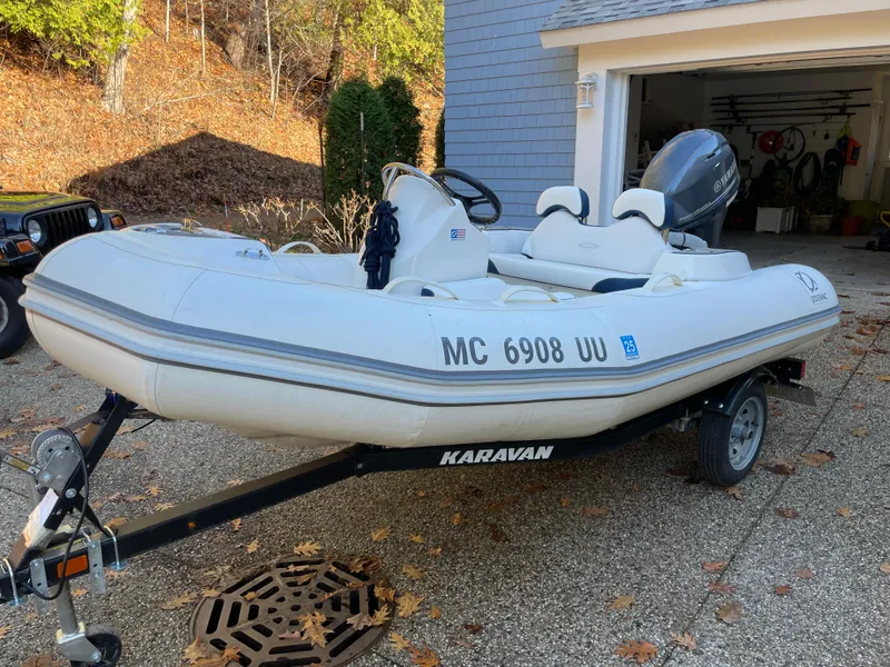 Slide: The Image of 2022 Zodiac Yachtline 360 inflatable boat on trailer, parked in driveway near garage. - 5
