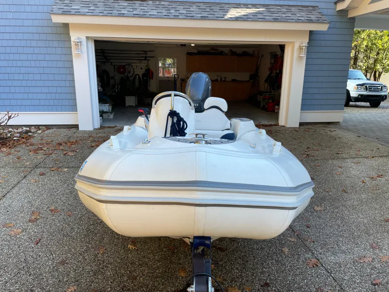 Slide: The Image of 2022 Zodiac Yachtline 360 inflatable boat parked in driveway near garage. - 6