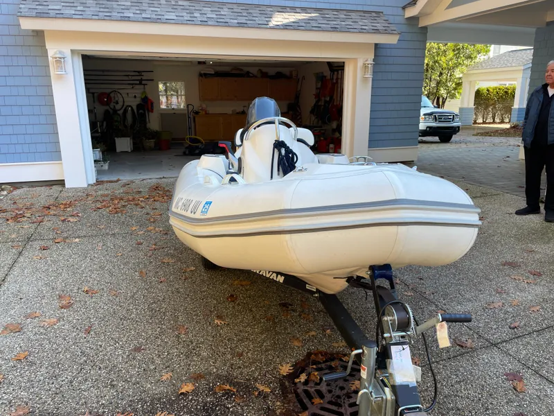 Slide: The Image of 2022 Zodiac Yachtline 360 inflatable boat on trailer in driveway near garage. - 8
