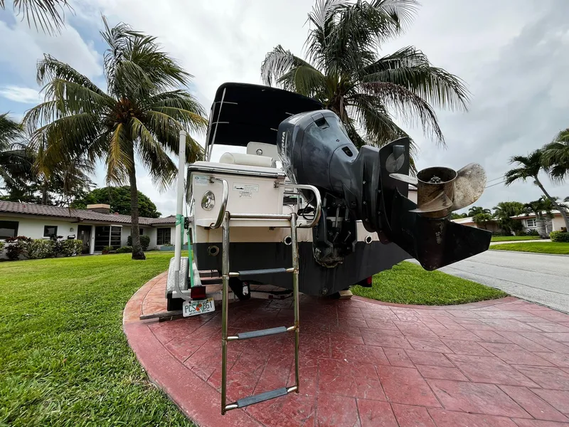 Slide: The Image of 2013 Grady-White Fisherman 180 boat with outboard motor, parked near palm trees. - 12