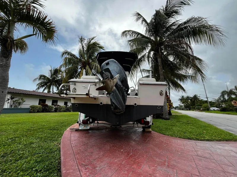 Slide: The Image of 2013 Grady-White Fisherman 180 boat on driveway, surrounded by palm trees and suburban landscape. - 15