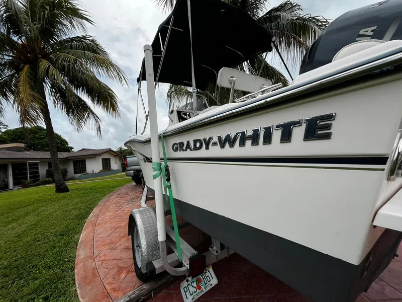 Slide: The Image of 2013 Grady-White Fisherman 180 boat on trailer, parked near palm trees and house. - 16