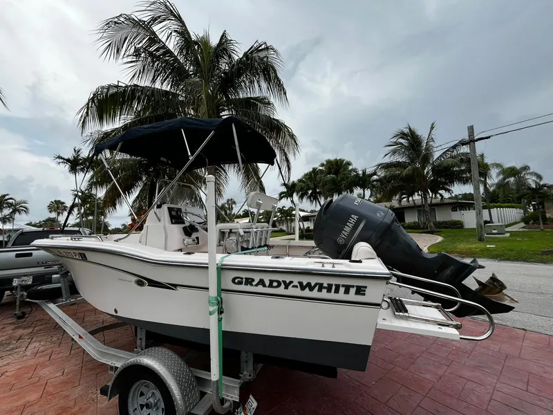 Slide: The Image of 2013 Grady-White Fisherman 180 boat on trailer, parked near palm trees. - 3