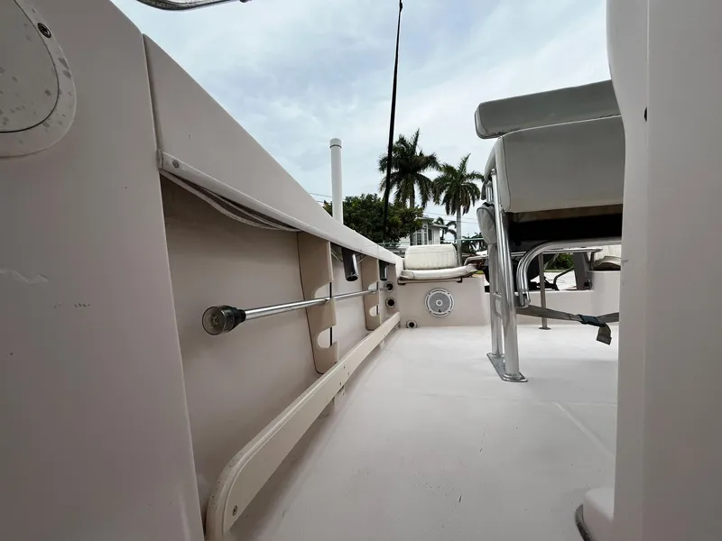 Slide: The Image of 2013 Grady-White Fisherman 180 boat interior with seating and rod holders, palm trees in background. - 33