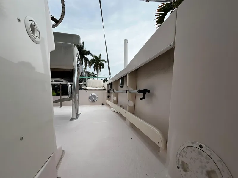 Slide: The Image of 2013 Grady-White Fisherman 180 boat interior with seating and storage, palm trees in background. - 35