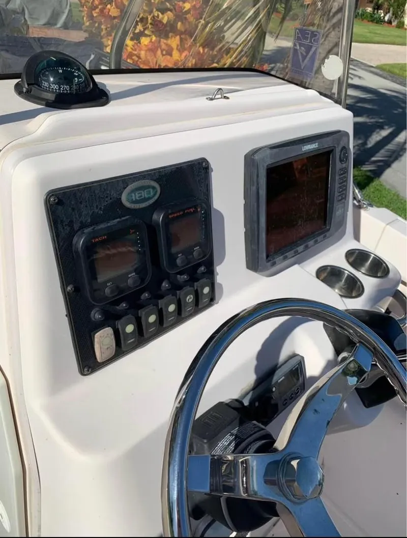 Slide: The Image of 2013 Grady-White Fisherman 180 boat dashboard with steering wheel and navigation instruments. - 42
