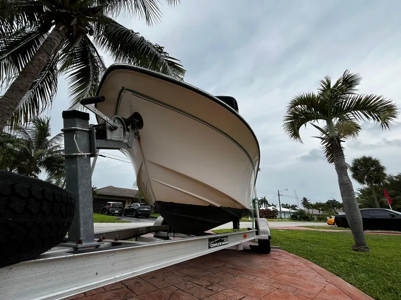 Slide: The Image of 2013 Grady-White Fisherman 180 boat on trailer, surrounded by palm trees. - 7
