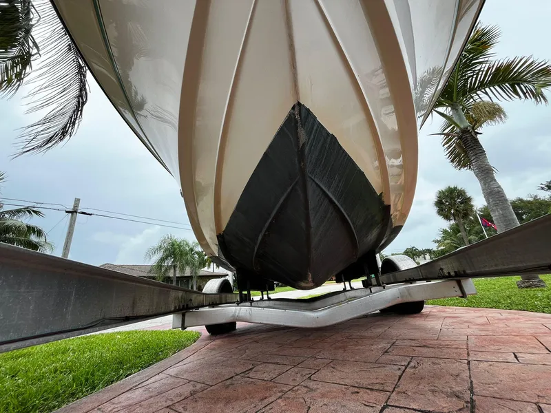Slide: The Image of 2013 Grady-White Fisherman 180 boat on trailer, viewed from below, with palm trees in background. - 8