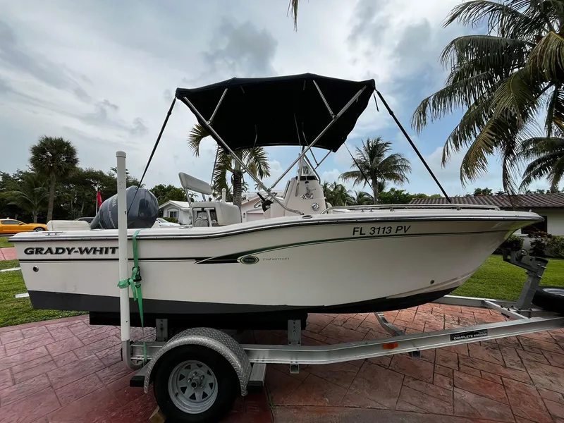 Slide: The Image of 2013 Grady-White Fisherman 180 boat on trailer, parked outdoors with palm trees. - 9