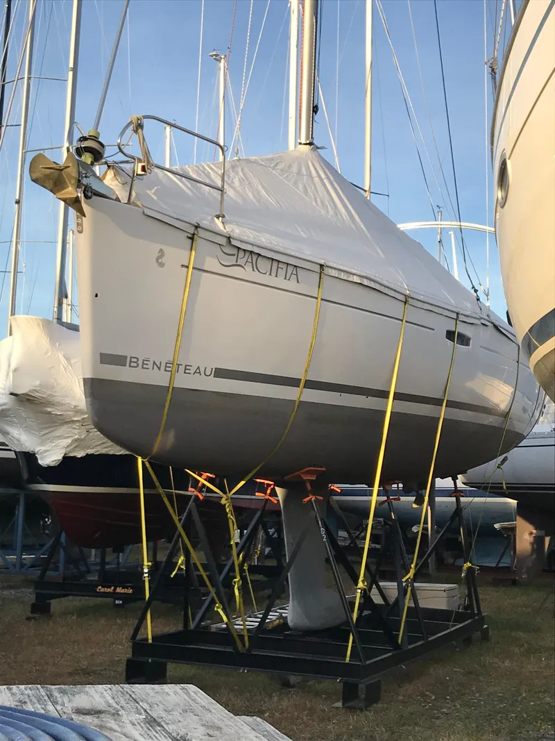 Slide: The Image of 2009 Beneteau Oceanis 34 sailboat secured on a stand, covered and ready for storage. - 1