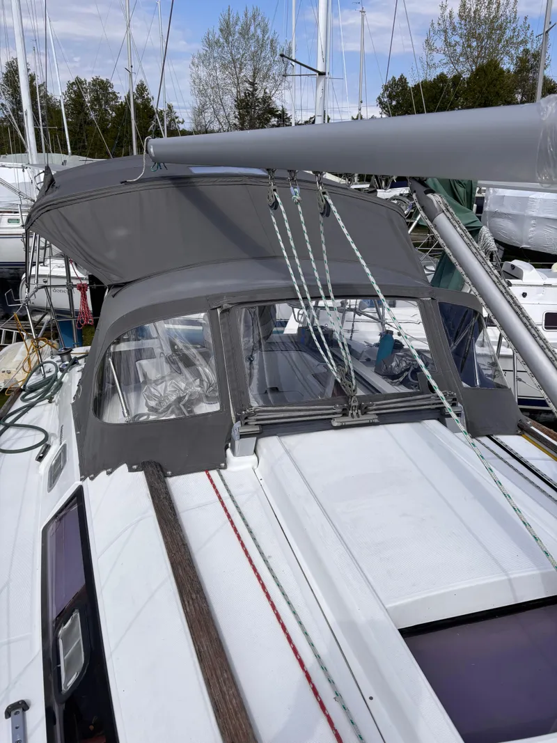 Slide: The Image of 2009 Beneteau Oceanis 34 sailboat with gray canopy, docked in a marina. - 5
