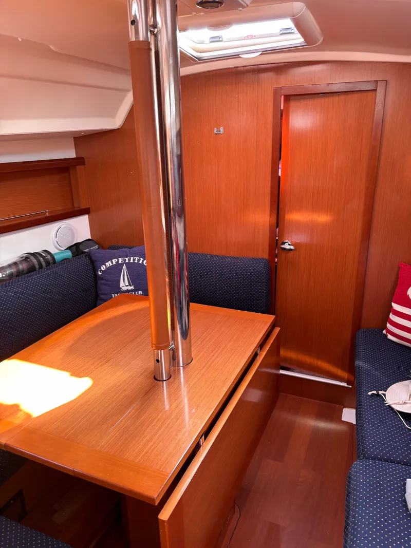 Slide: The Image of Interior of 2009 Beneteau Oceanis 34 sailboat with wooden furnishings and cozy seating. - 6