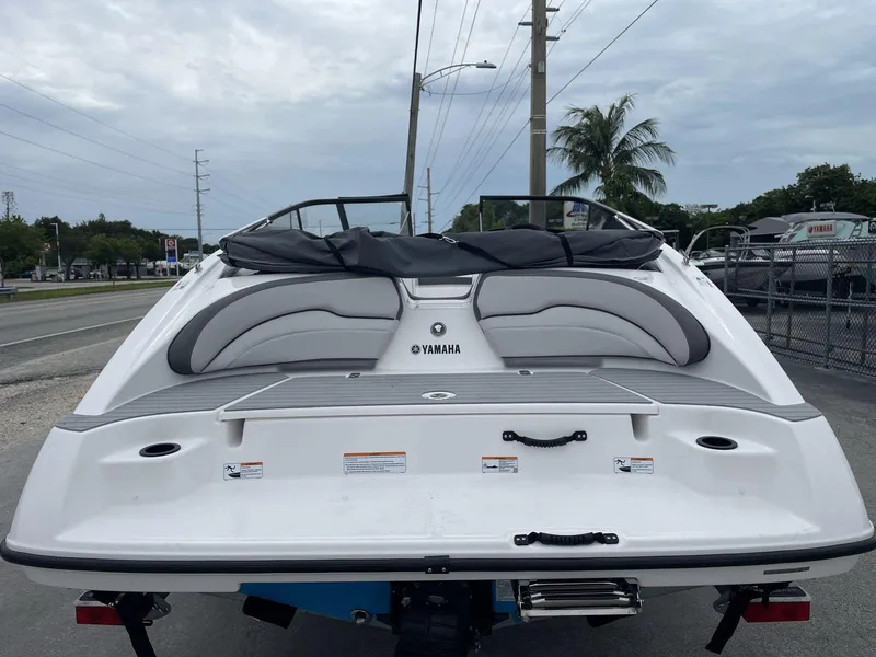 Slide: The Image of 2025 Yamaha Boats SX190, rear view, white exterior, parked outdoors. - 32