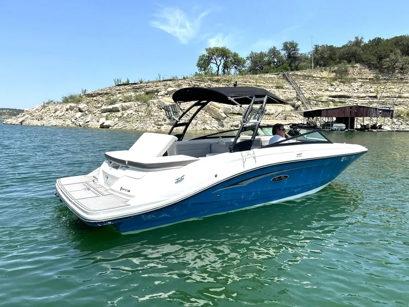 Slide: The Image of 2020 Sea Ray SPX 230 boat on a scenic lake with rocky shoreline. - 10