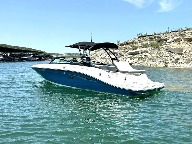 Slide: The Image of 2020 Sea Ray SPX 230 boat on a sunny lake with rocky shoreline. - 15
