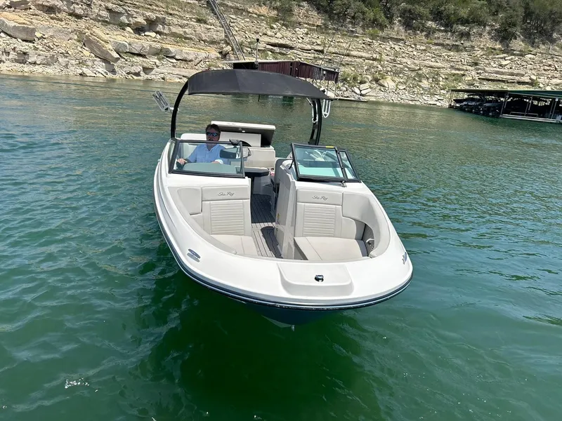 Slide: The Image of 2020 Sea Ray SPX 230 boat on a lake with rocky shoreline. - 19