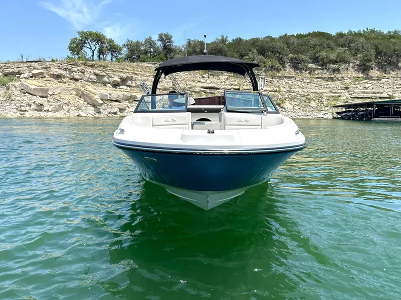 Slide: The Image of 2020 Sea Ray SPX 230 boat on clear water with rocky shoreline background. - 20