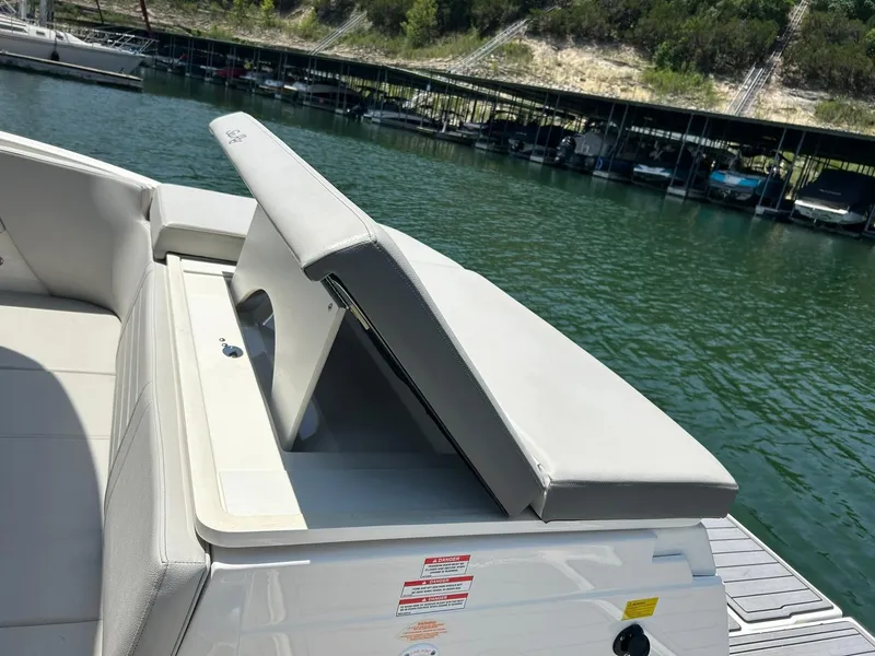 Slide: The Image of 2020 Sea Ray SPX 230 boat with open storage compartment by a marina. - 25