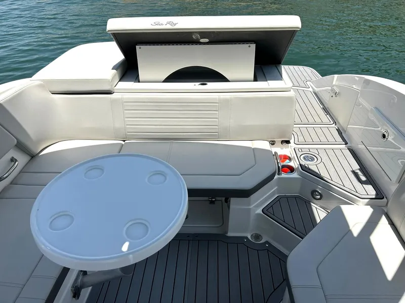 Slide: The Image of 2020 Sea Ray SPX 230 boat interior with seating and table on the water. - 26