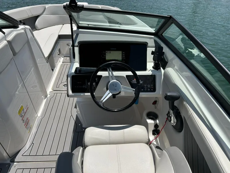 Slide: The Image of 2020 Sea Ray SPX 230 boat cockpit with steering wheel and dashboard on water. - 3