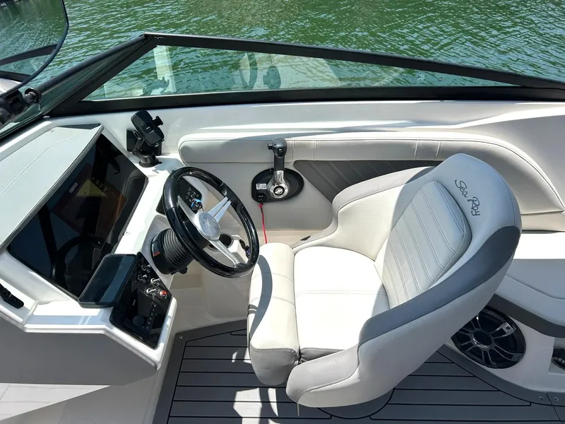 Slide: The Image of 2020 Sea Ray SPX 230 boat cockpit with steering wheel and comfortable seating. - 38