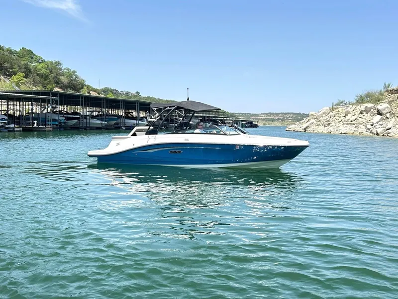 Slide: The Image of 2020 Sea Ray SPX 230 boat on a sunny lake with rocky shoreline. - 7