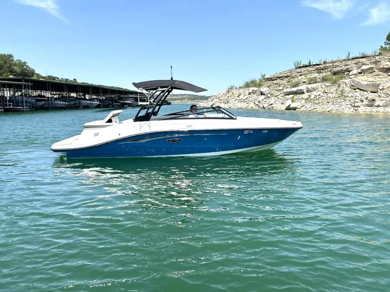 Slide: The Image of 2020 Sea Ray SPX 230 boat on a sunny lake with rocky shoreline. - 8