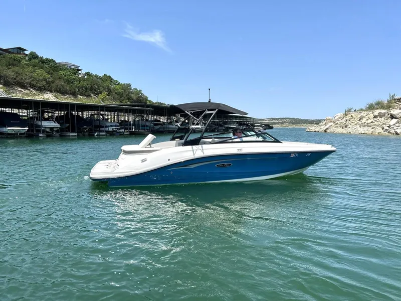 Slide: The Image of 2020 Sea Ray SPX 230 boat on a sunny lake with clear blue water. - 9